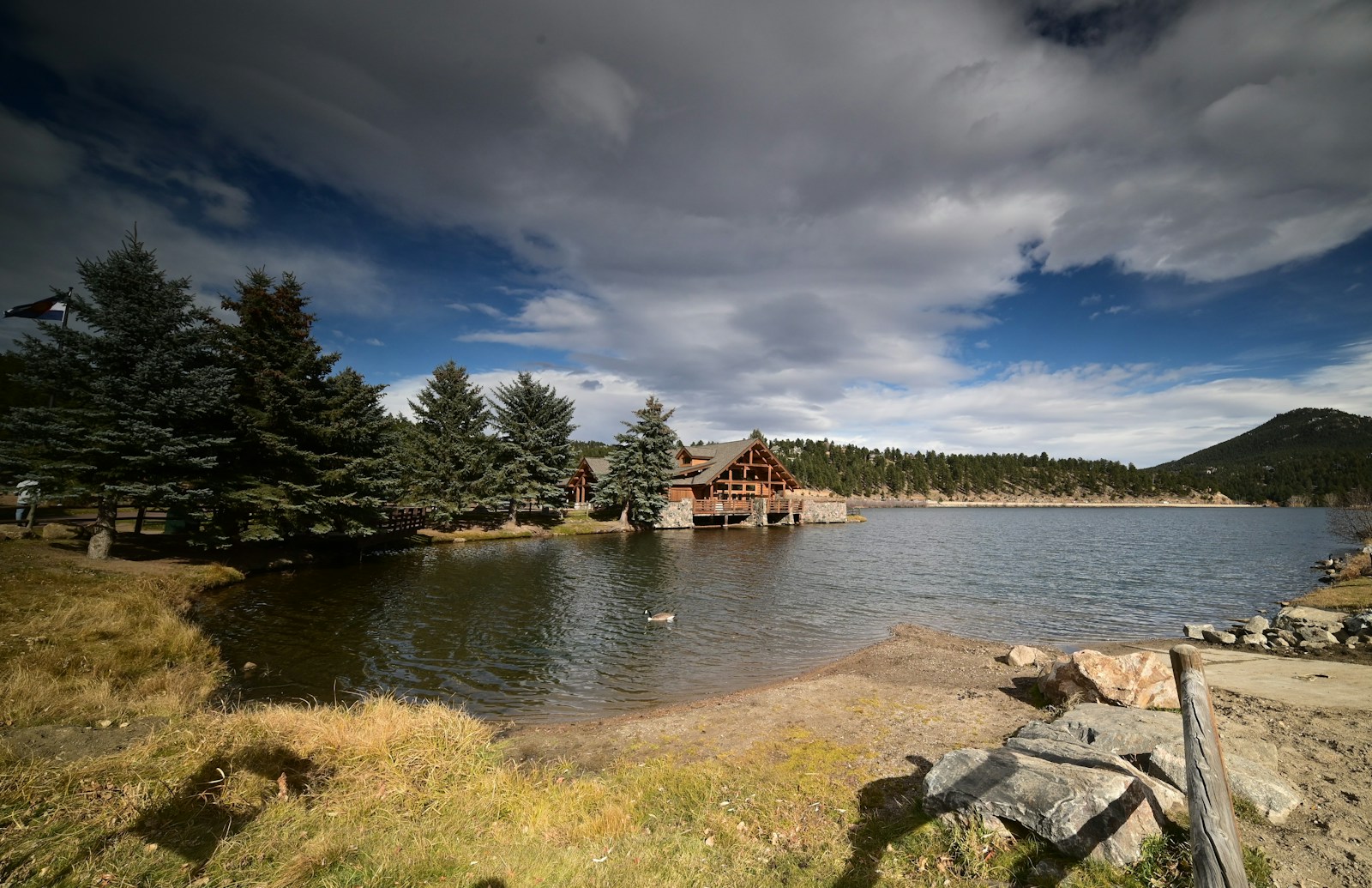 Log cabin beside a lake and pine trees