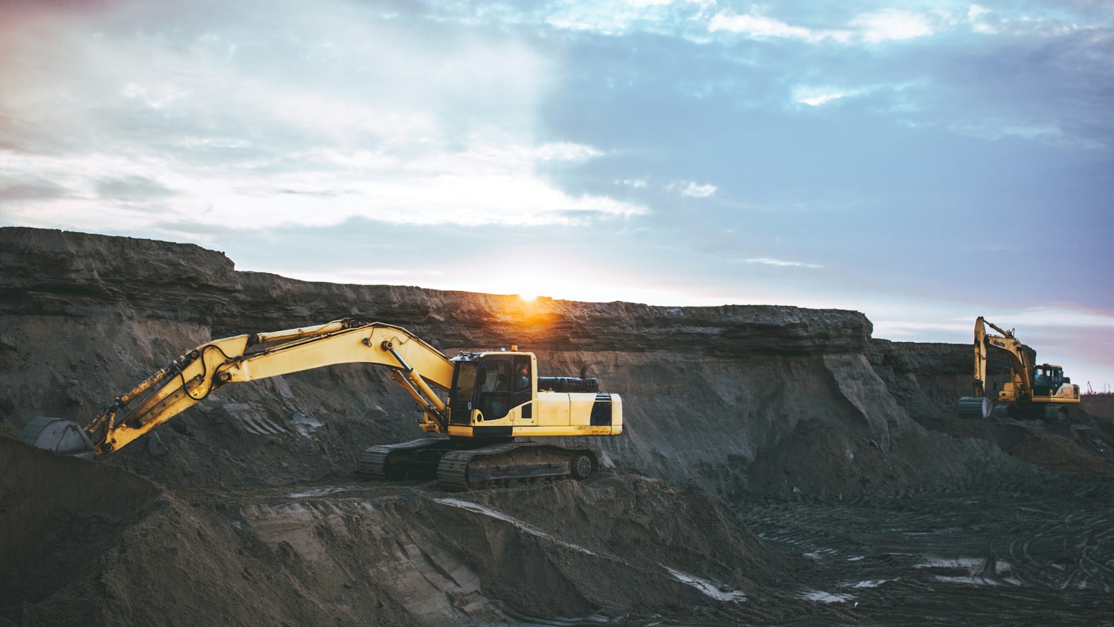 Two excavators on exposed rocky ground