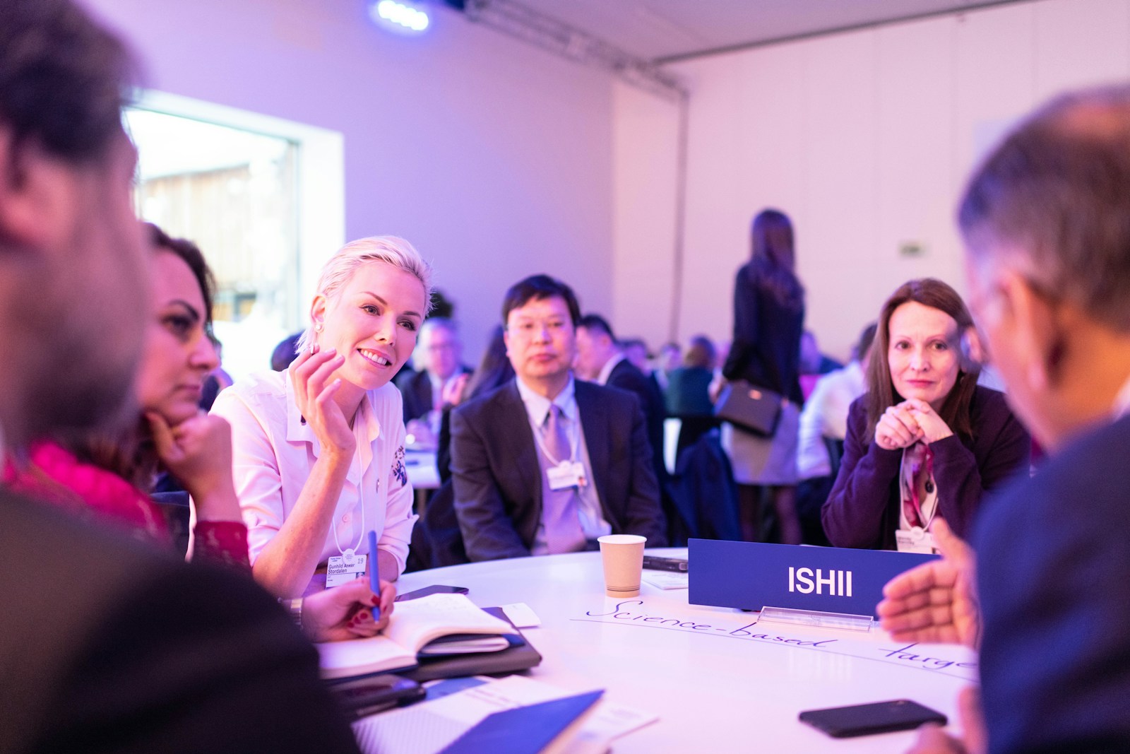 Participants taking notes around a table at a learning event